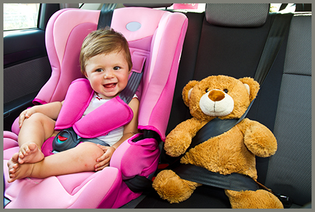 Image of smiling baby girl in carseat